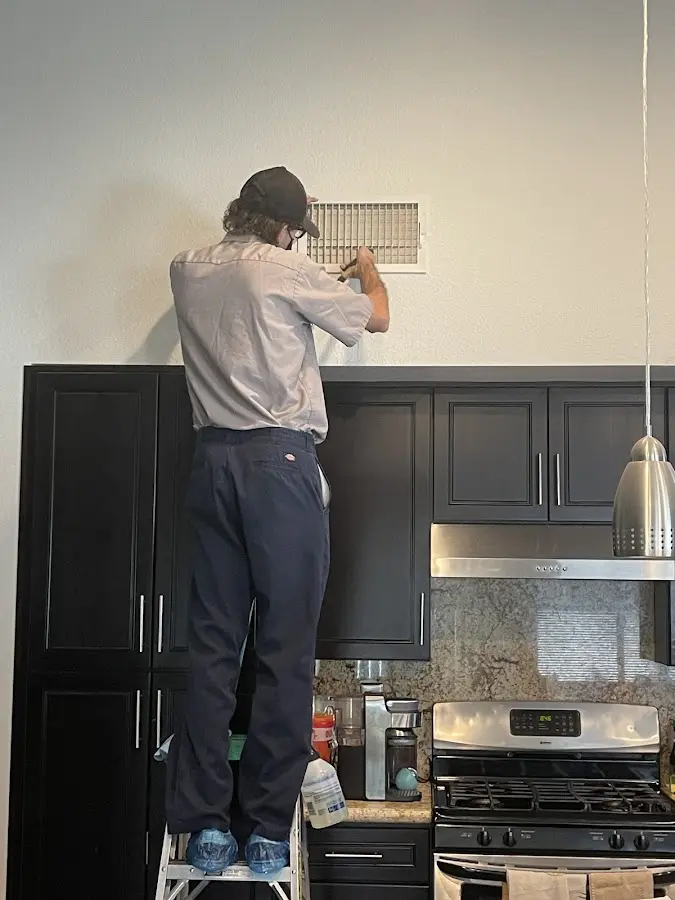 Technician inspecting an air vent during HVAC service in Silver Spring